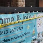 Banner reading come  join with phone number 0813 2885 9659 and blogspot url taped behind yellow caution tape at a storefront