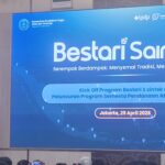 Speaker at a podium in front of a large blue conference banner reading bestari saintek with event details indonesian flag visible on the left and an audience in the foreground