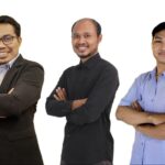 Three men stand side by side with arms crossed smiling at the camera against a white backgroundgroup portrait of colleaguespartners