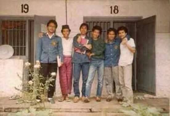 Fbimg1777369505209 catrawarta Six friends posing closely in front of a building with doors labeled 18 and 19