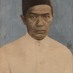 Historic portrait of a man wearing a white traditional tunic and a dark fez like hat looking straight ahead with a neutral expression