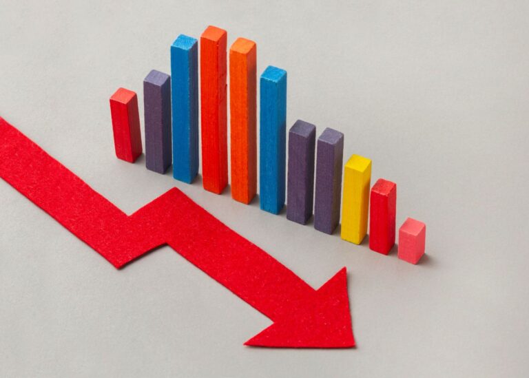 Colorful bar chart showing a downward trend with a large red arrow pointing downward across a light gray background.