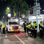 Nighttime traffic stop with police officers a marked police suv and motorbikes on a dimly lit street