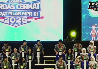 Contestants seated on a tiered stage wearing matching patterned shirts and green id badges during a competition window of a quizcontest event