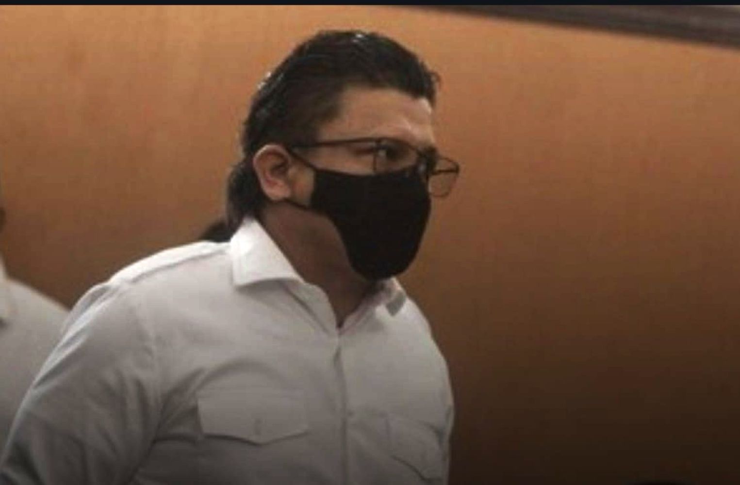 13eferdi catrawarta Man in a white shirt wearing a black face mask and glasses indoors profile view