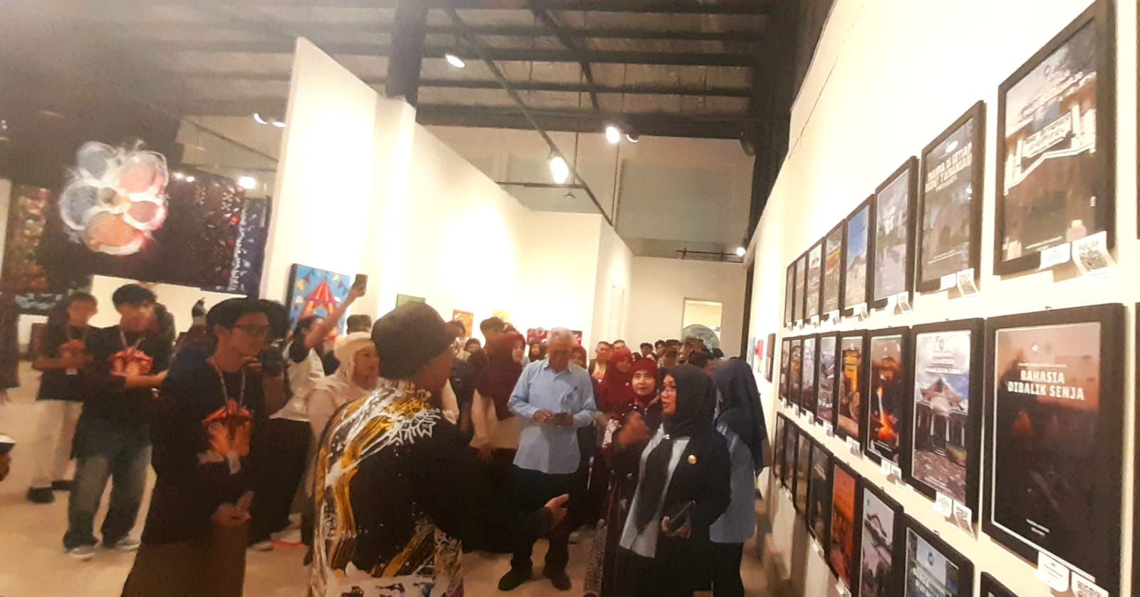 15swn catrawarta Crowd of people in a white walled art gallery viewing framed posters on the wall