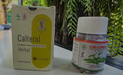 Boxes of herbal supplements (Calterol Herbal) and Calcusol bottle on a table outdoors among greenery, showing labels and logos.