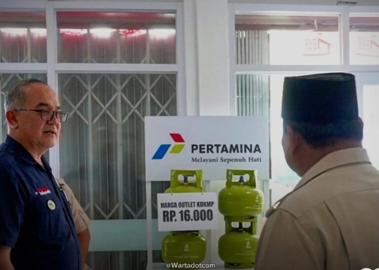Two men stand near a display of green gas cylinders beside a Pertamina sign that reads 'Melayani Sepenuh Hati'.