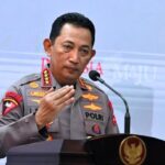 Indonesian police general in gray uniform speaking at a podium gesturing with his right hand