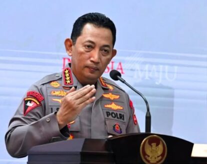 Indonesian police general in gray uniform speaking at a podium, gesturing with his right hand.
