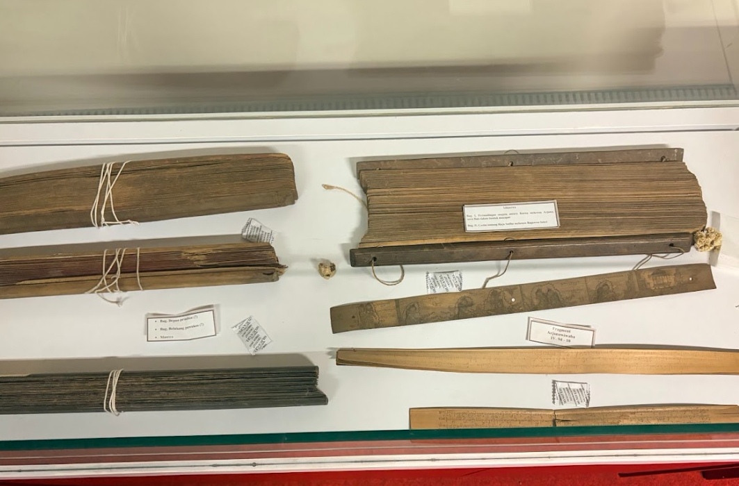 14fnaskah catrawarta Display case containing bundled parchment scrolls tied with string and several wooden rulers with labels as a museum exhibit item