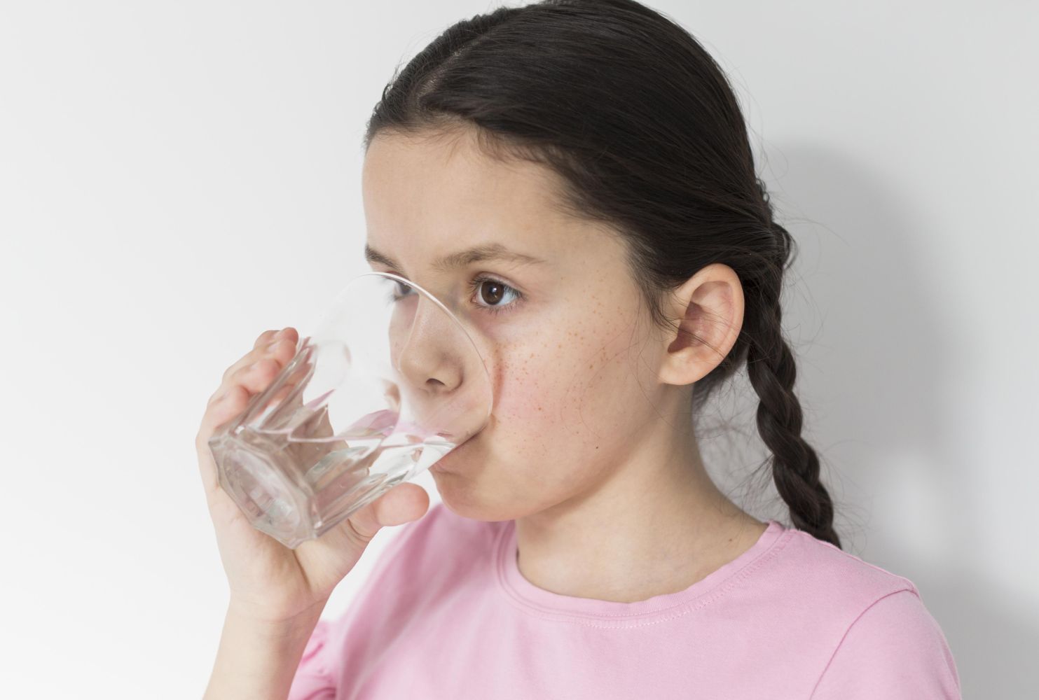 15fminum catrawarta Girl wearing a pink shirt drinking water from a clear glass