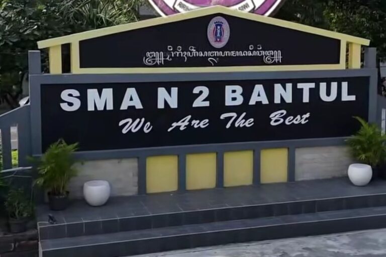Signboard for SMA N 2 Bantul with the slogan 'We Are The Best' in front of a dark panel and yellow framing.