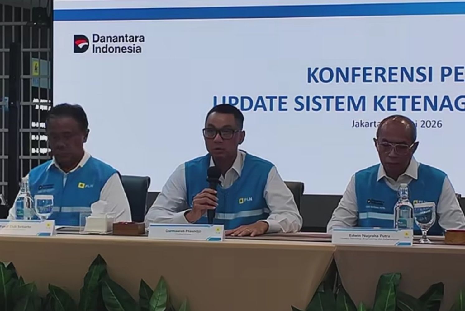 20fpln catrawarta Three men in blue vests sit at a conference panel the center one speaking into a microphone with a banner reading danantara indonesia in the background