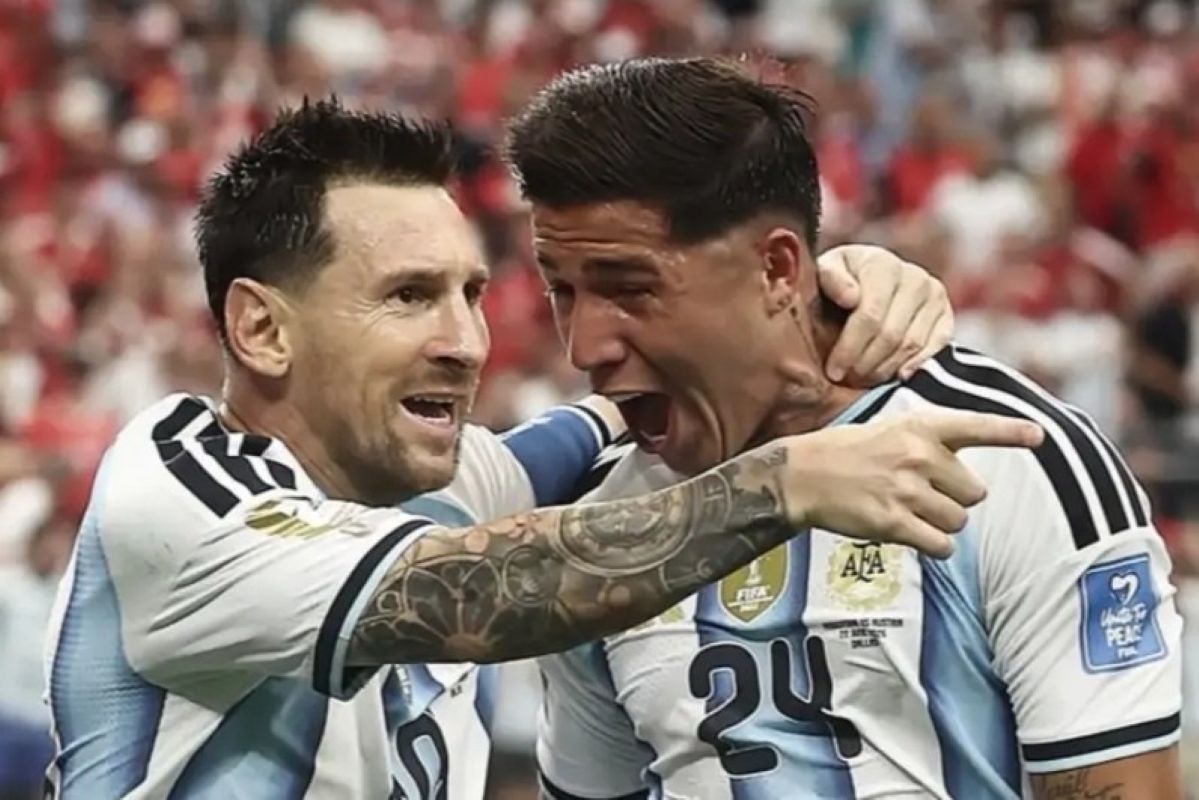 Two argentina players celebrate a goal embracing and shouting with arms around each other on the field