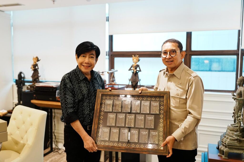 Menteri kebudayaan dukung penyelenggaraan indonesia international culture festival 2026 1 catrawarta Two men in an office hold a framed display of small metal plaques or cards between them
