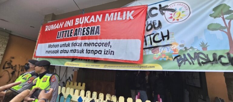 Large red banner in Indonesian says 'RUMAH INI BUKAN MILIK LITTLE ARESHA' with police/security officers in neon vests and onlookers nearby.