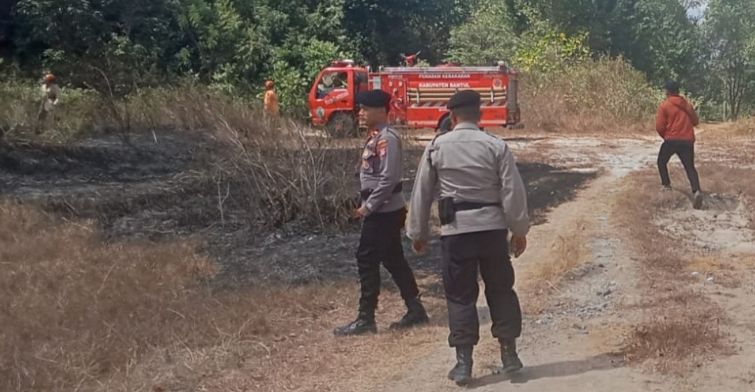 Kebakaran di lahan kosong piyungan bantul catrawarta Firefighters and police at a burned clearing with a red fire truck in the background