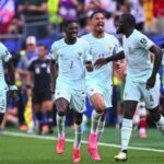 French national team players in light blue kits celebrate on the pitch after a goal running together with smiles