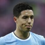 Close up of a male soccer player in a light blue jersey looking to the right on the field