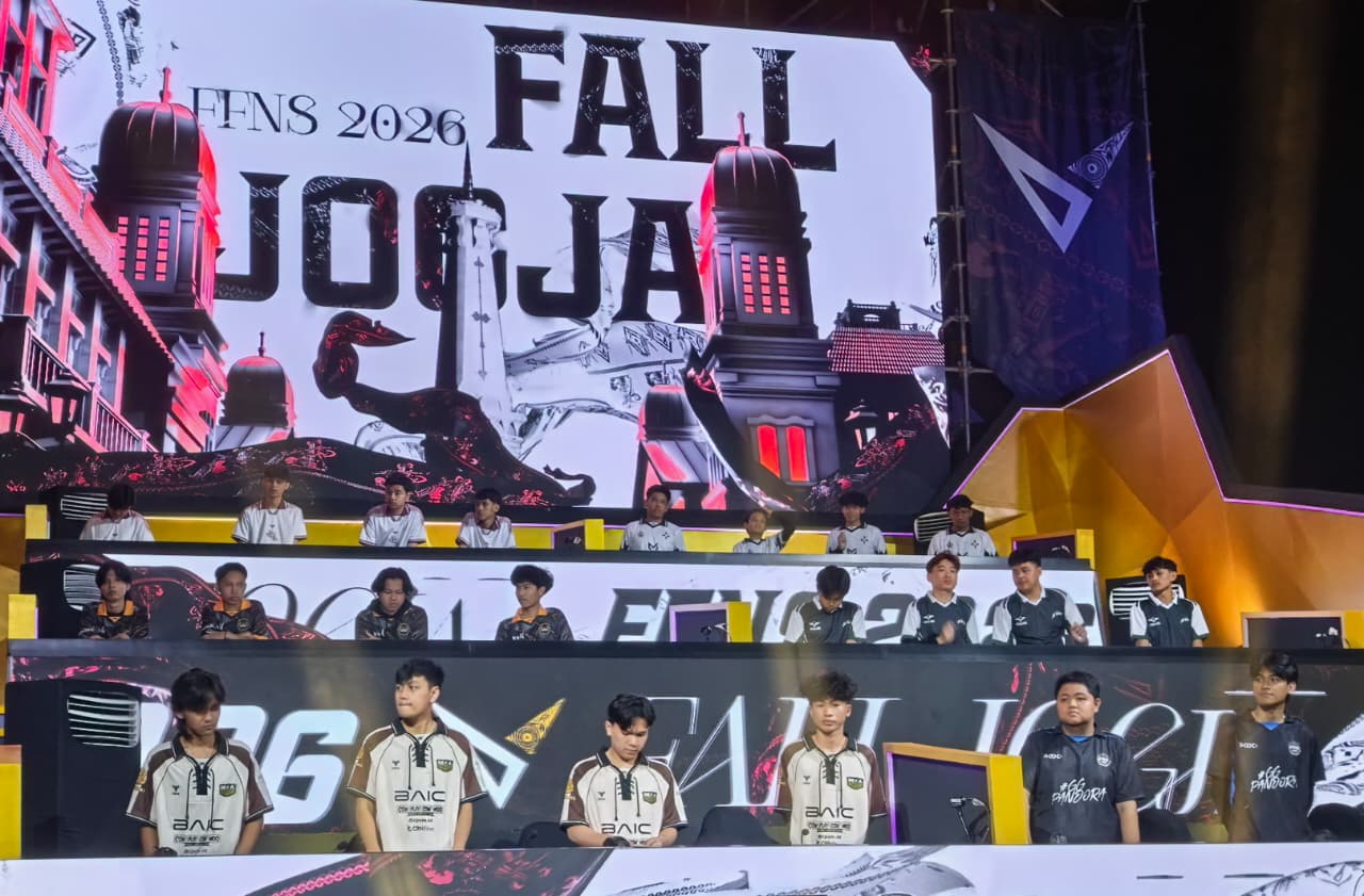 12ggame catrawarta Team of esports players in matching jerseys standing and seated on a multi tier stage during a tournament with a large digital backdrop displaying bold text and architectural graphics behind them