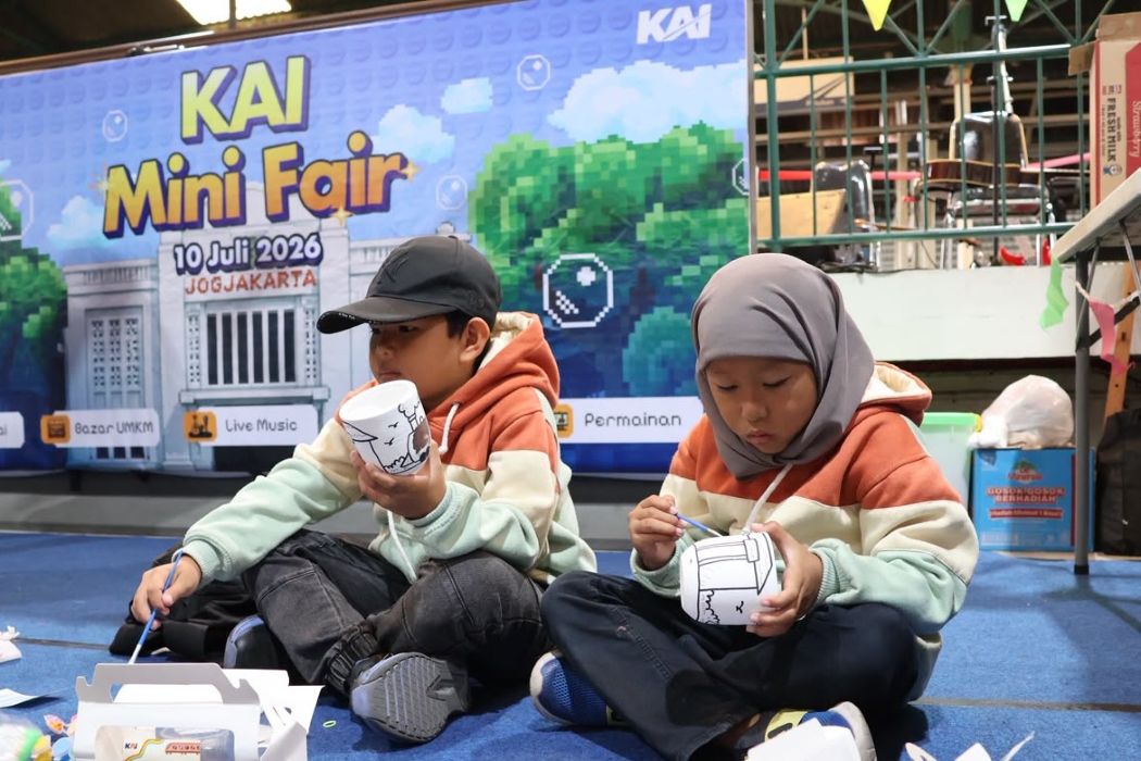 13gmewarnai catrawarta Two kids in hoodies sit on a blue floor painting white paper cups at a craft station during kai mini fair