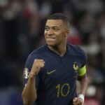 French footballer wearing a navy france jersey with number 10 fist pumped in celebration