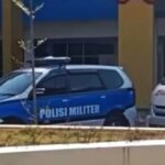 Military police car polisi militer in blue and white parked near a building with yellow columns emergency vehicle nearby