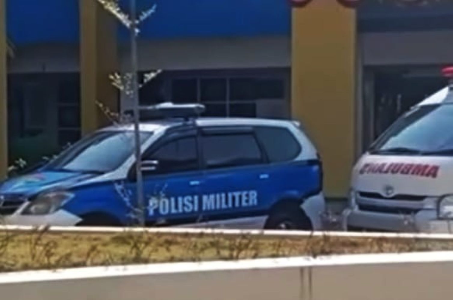16gtni catrawarta Military police car polisi militer in blue and white parked near a building with yellow columns emergency vehicle nearby
