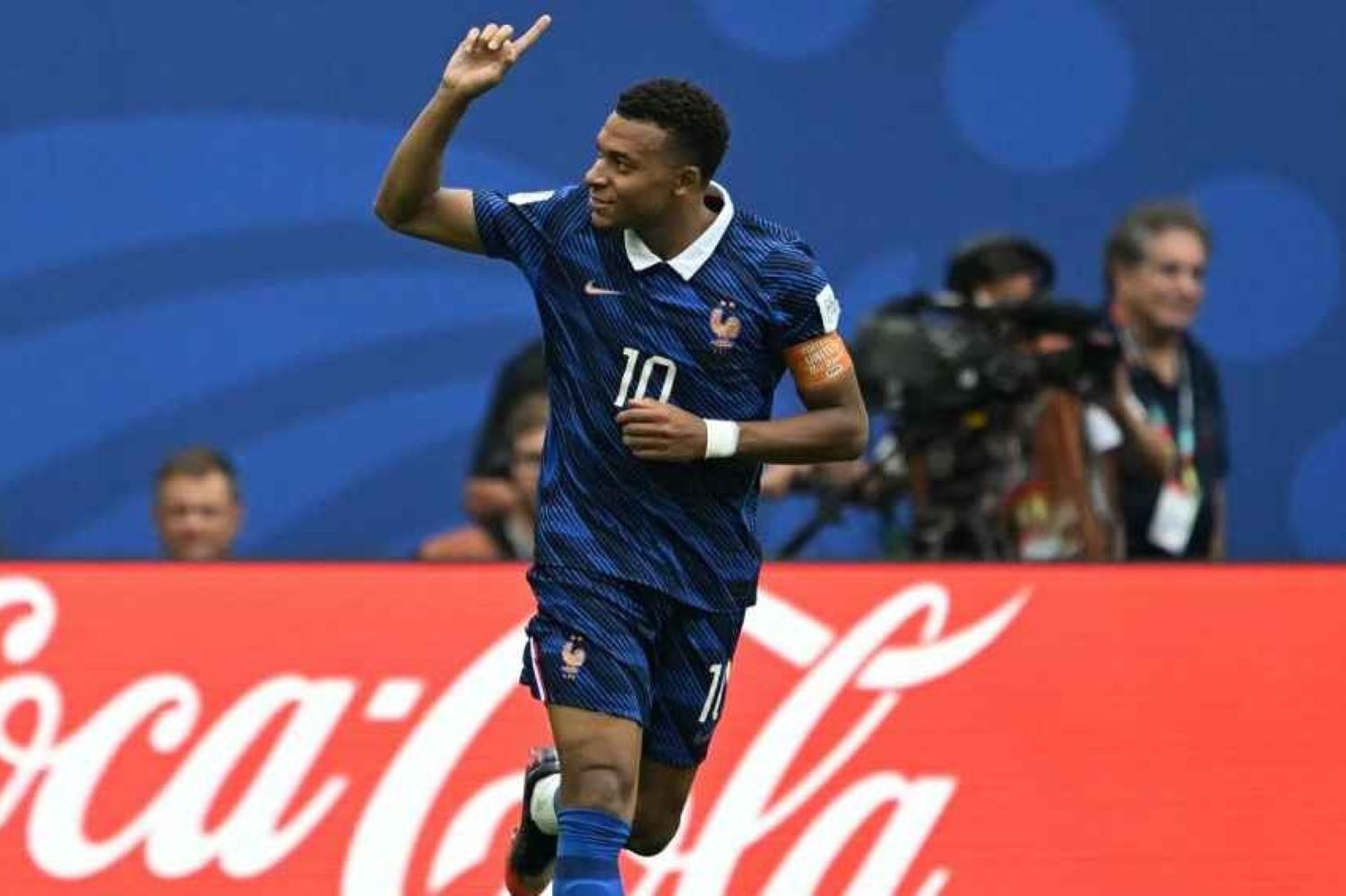 19gmbappe1 catrawarta France national team footballer wearing number 10 raises his arm in celebration on the pitch cocacola ad boards in the background
