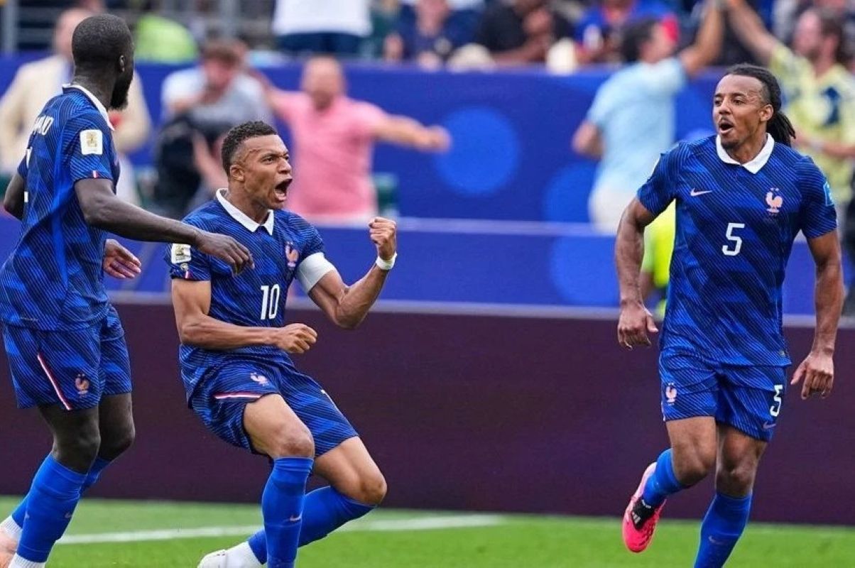 3gmbappe1 catrawarta French soccer players celebrate a goal central player wearing number 10 clenches a fist with teammates nearby in blue kits