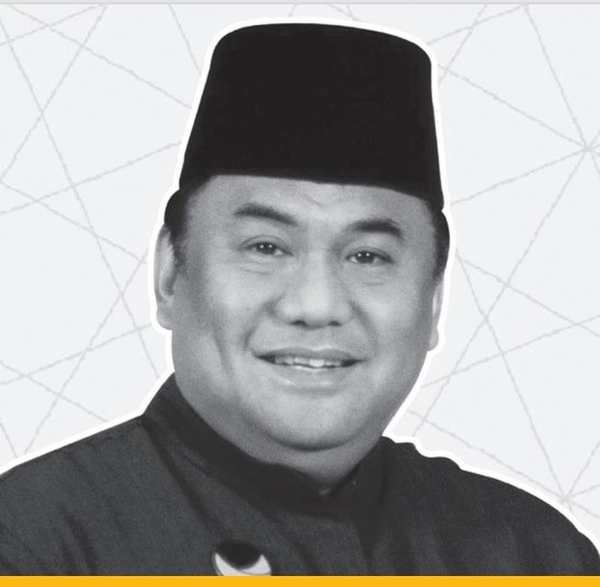 5f3423ed3782e784106609 catrawarta Smiling man in a traditional black cap and dark clothing against a pale geometric backdrop