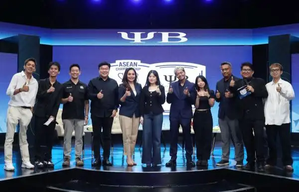 Twelve people on a stage posing for a group photo giving thumbs up with a blue backdrop featuring asean championship branding and a large yb logo