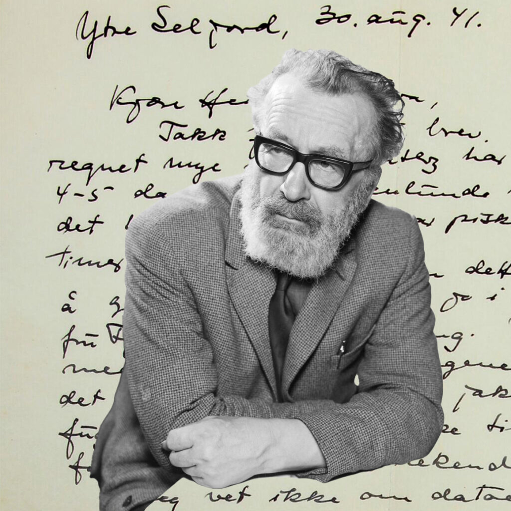Portrait of an older man with a gray beard and glasses in a suit leaning forward against a backdrop of handwritten cursive text
