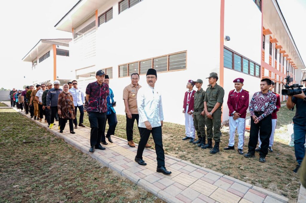 Download 31 catrawarta Officials and uniformed attendees line a brick path outside a modern white building during a ceremony