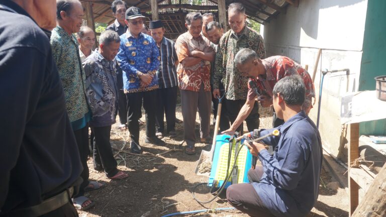 Img20260717wa0063768x432 catrawarta Group of men gathered around a man kneeling to operate a blue portable water pump during a training session outdoors