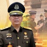 Indonesian prosecutor in a formal uniform with medals posed in front of a kejaksaan agung backdrop