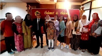 Screenshot 46 1 catrawarta Group of people posing indoors at a celebration with a red banner backdrop