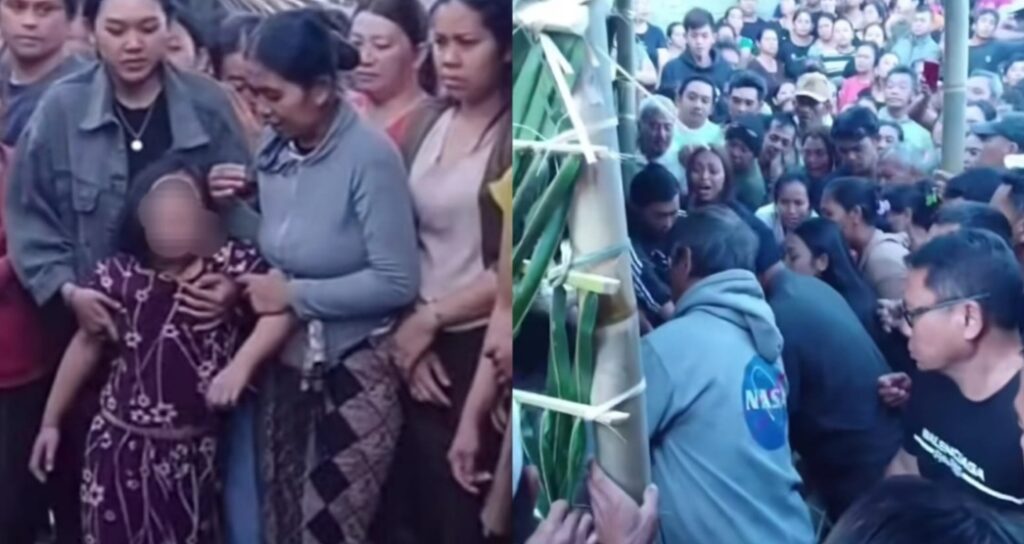 Large crowd of people surrounding a small child held by several adults outdoors at a crowded event
