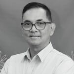Obituary banner with a man in a light shirt and glasses on a blue gradient background with a cross and indonesian memorial text