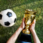 Ilustrasi memegang trofi piala dunia 2026 di atas rumput